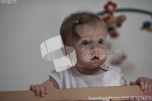 Image of cute little one year old baby and making first steps in bed