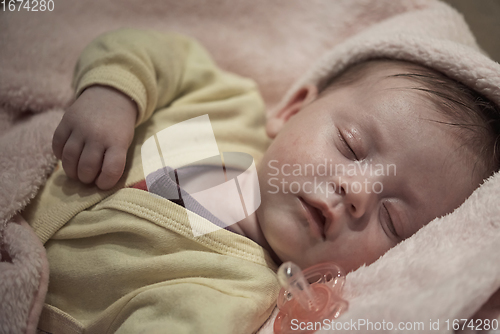 Image of newborn baby sleeping at home in bed