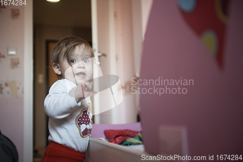 Image of cute little one year old baby and making first steps