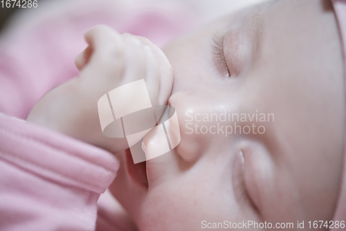 Image of newborn baby sleeping at home in bed