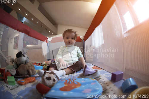 Image of cute little baby playing in mobile bed
