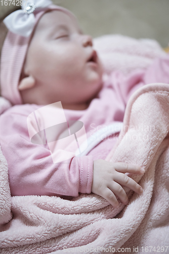 Image of newborn baby sleeping at home in bed