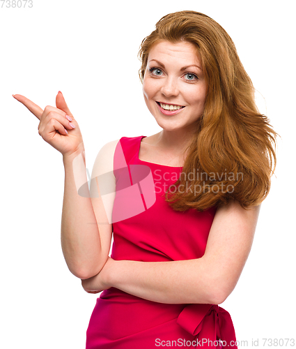 Image of Portrait of a young woman pointing to the left