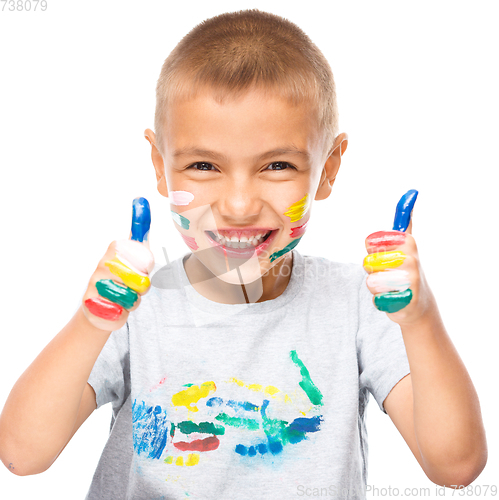 Image of Portrait of a cute boy playing with paints