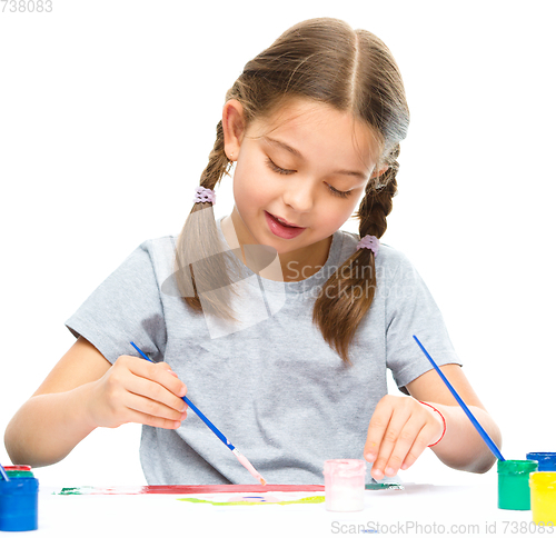 Image of Little girl is painting with gouache