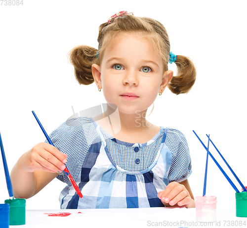 Image of Little girl is painting with gouache