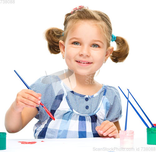 Image of Little girl is painting with gouache