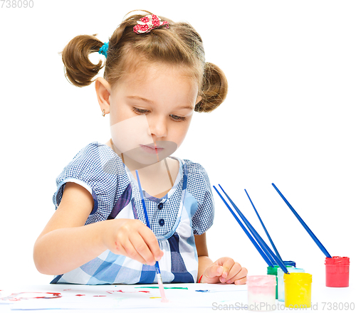 Image of Little girl is painting with gouache