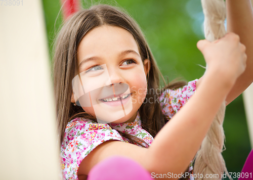 Image of Cute little girl is playing in playground