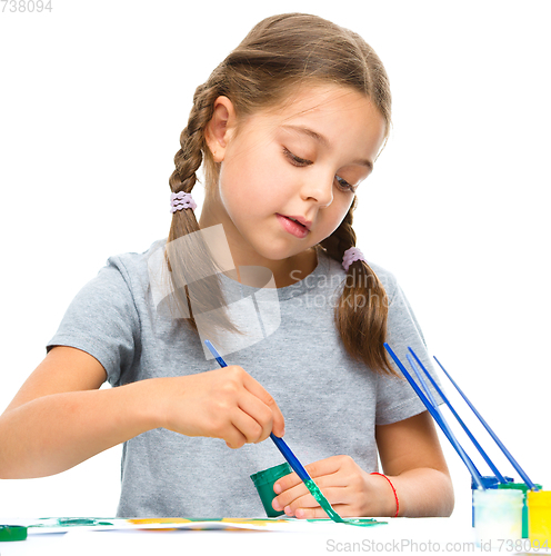 Image of Little girl is painting with gouache