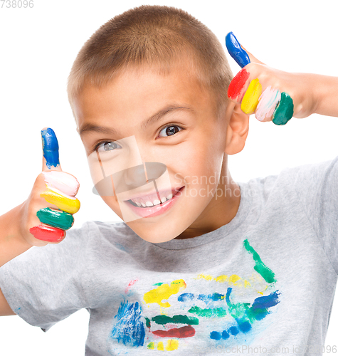Image of Portrait of a cute boy playing with paints