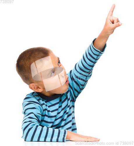 Image of Little boy is pointing up using his index finger
