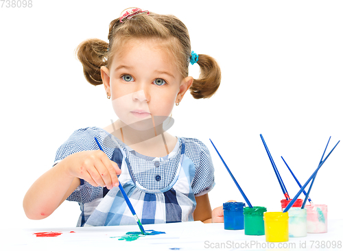 Image of Little girl is painting with gouache