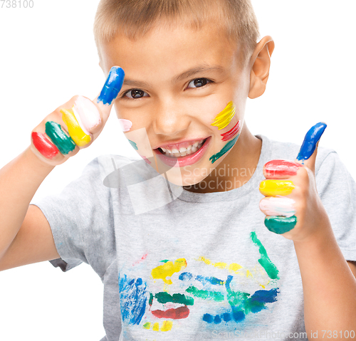 Image of Portrait of a cute boy playing with paints