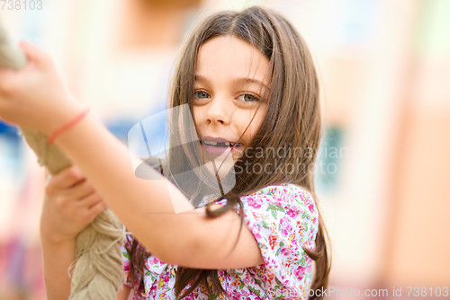 Image of Cute little girl is playing in playground