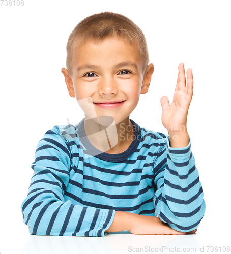Image of Little boy is rising his hand up