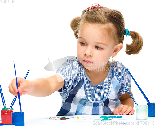 Image of Little girl is painting with gouache