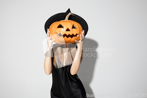 Image of Young woman in hat as a witch on white background