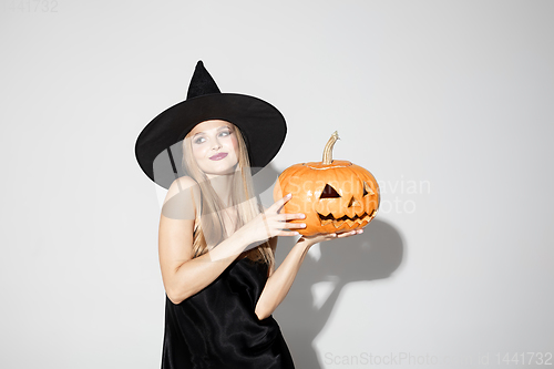 Image of Young woman in hat as a witch on white background