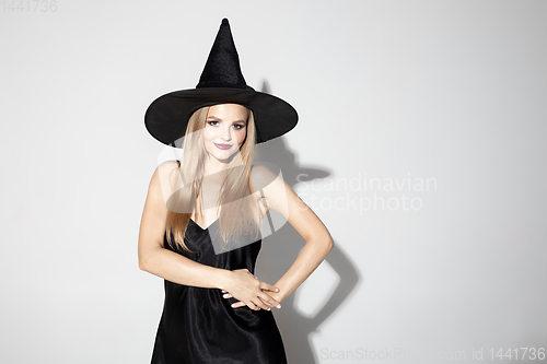 Image of Young woman in hat as a witch on white background