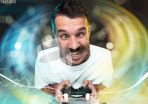 Image of Enthusiastic gamer. Joyful young man holding a video game controller