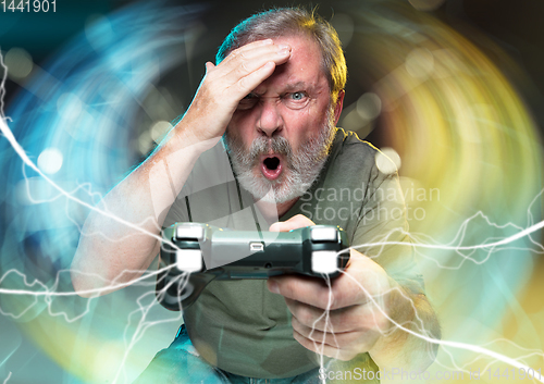 Image of Enthusiastic gamer. Joyful man holding a video game controller