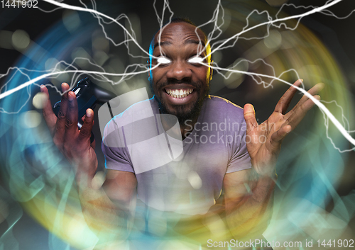 Image of Enthusiastic gamer. Joyful young man holding a video game controller