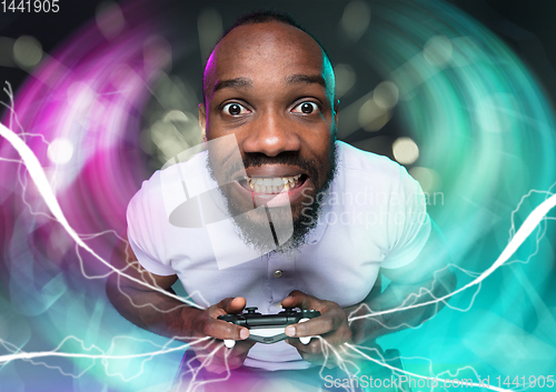 Image of Enthusiastic gamer. Joyful young man holding a video game controller