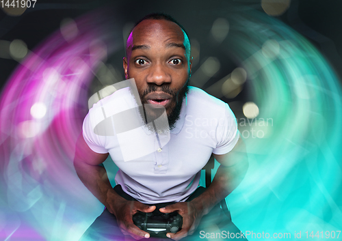 Image of Enthusiastic gamer. Joyful young man holding a video game controller