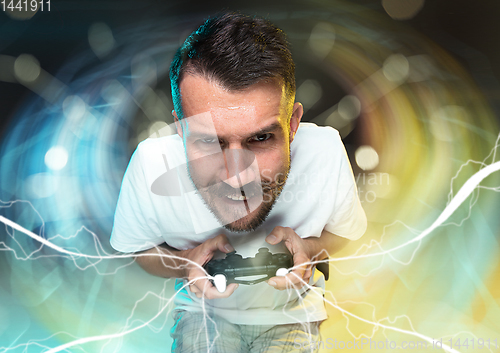 Image of Enthusiastic gamer. Joyful young man holding a video game controller