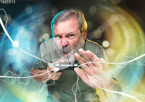 Image of Enthusiastic gamer. Joyful man holding a video game controller