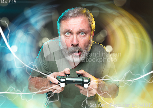 Image of Enthusiastic gamer. Joyful man holding a video game controller