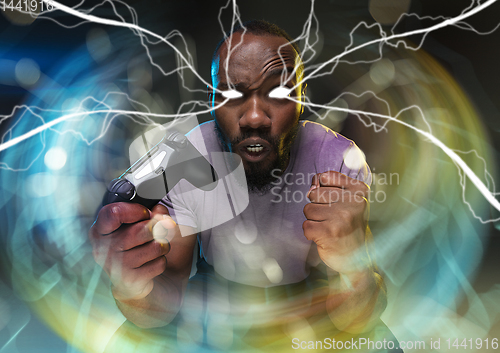 Image of Enthusiastic gamer. Joyful young man holding a video game controller