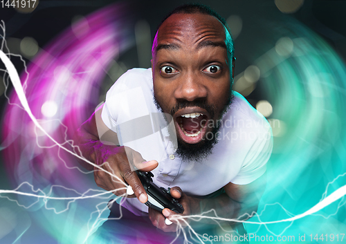 Image of Enthusiastic gamer. Joyful young man holding a video game controller