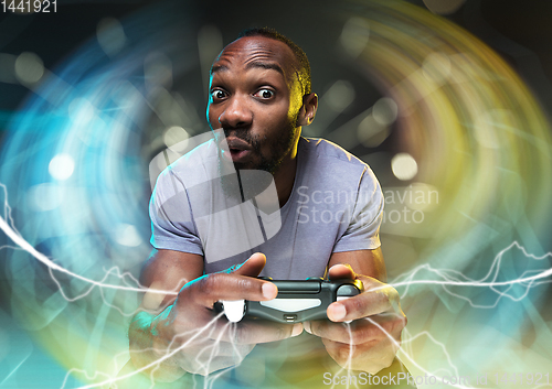 Image of Enthusiastic gamer. Joyful young man holding a video game controller