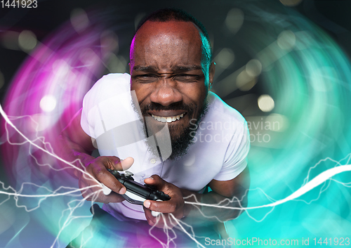 Image of Enthusiastic gamer. Joyful young man holding a video game controller