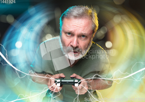 Image of Enthusiastic gamer. Joyful man holding a video game controller