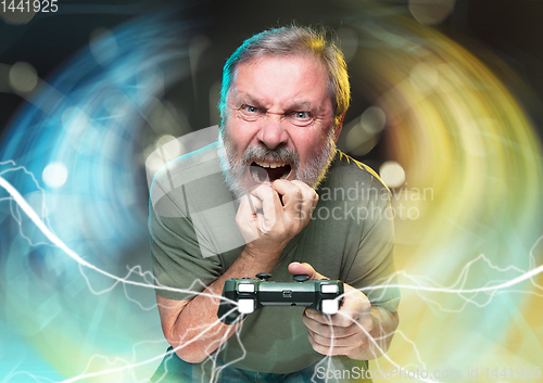 Image of Enthusiastic gamer. Joyful man holding a video game controller