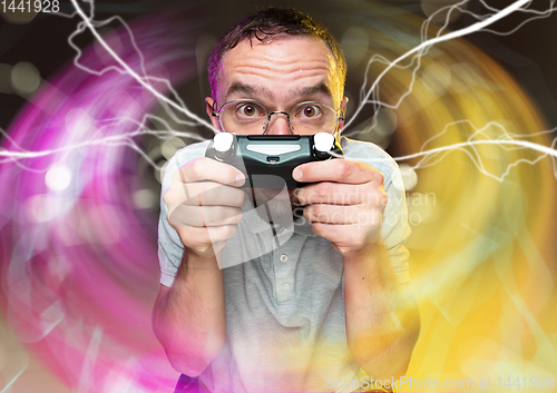 Image of Enthusiastic gamer. Joyful young man holding a video game controller