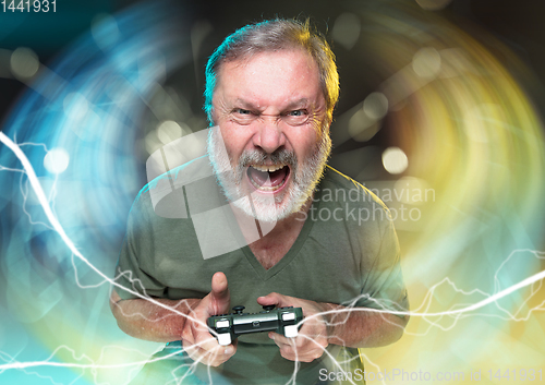 Image of Enthusiastic gamer. Joyful man holding a video game controller