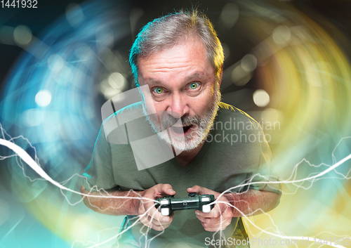 Image of Enthusiastic gamer. Joyful man holding a video game controller