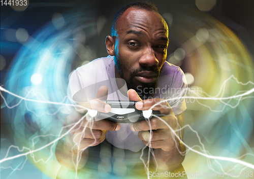 Image of Enthusiastic gamer. Joyful young man holding a video game controller