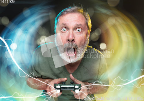 Image of Enthusiastic gamer. Joyful man holding a video game controller