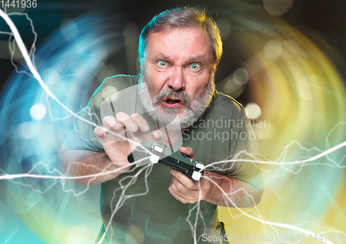 Image of Enthusiastic gamer. Joyful man holding a video game controller