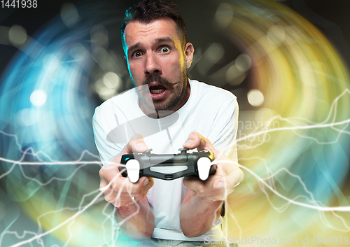 Image of Enthusiastic gamer. Joyful young man holding a video game controller