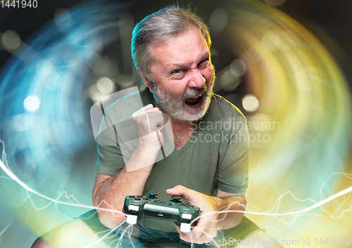 Image of Enthusiastic gamer. Joyful man holding a video game controller