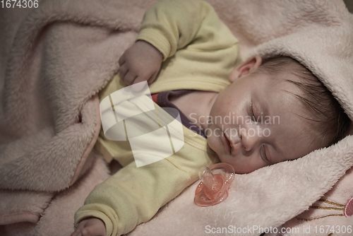 Image of newborn baby sleeping at home in bed