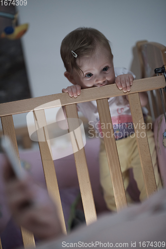 Image of cute little one year old baby and making first steps in bed