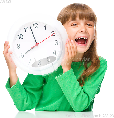 Image of Little girl is holding big clock