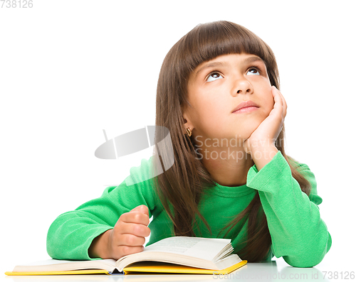 Image of Young girl is daydreaming while reading book
